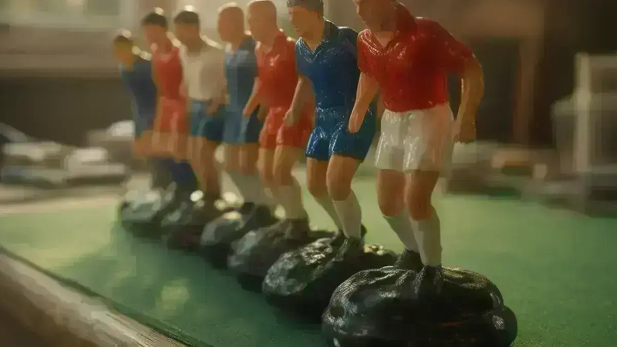 Squadre di Subbuteo di epoche diverse allineate sul panno verde, con le basi a cupola e le scatole numerate